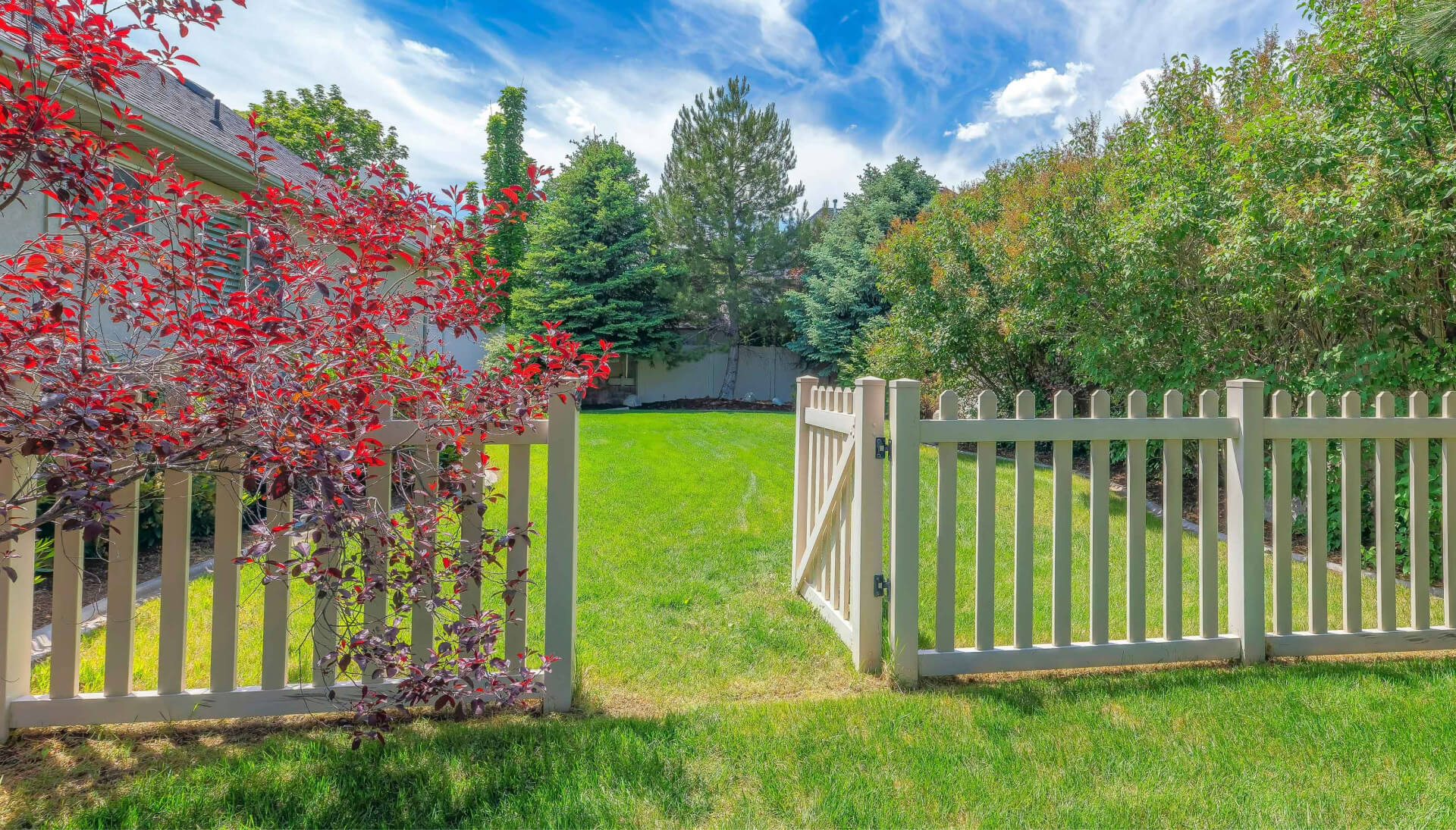 A functional fence gate providing access to a well-maintained backyard, surrounded by a wooden fence in Durham